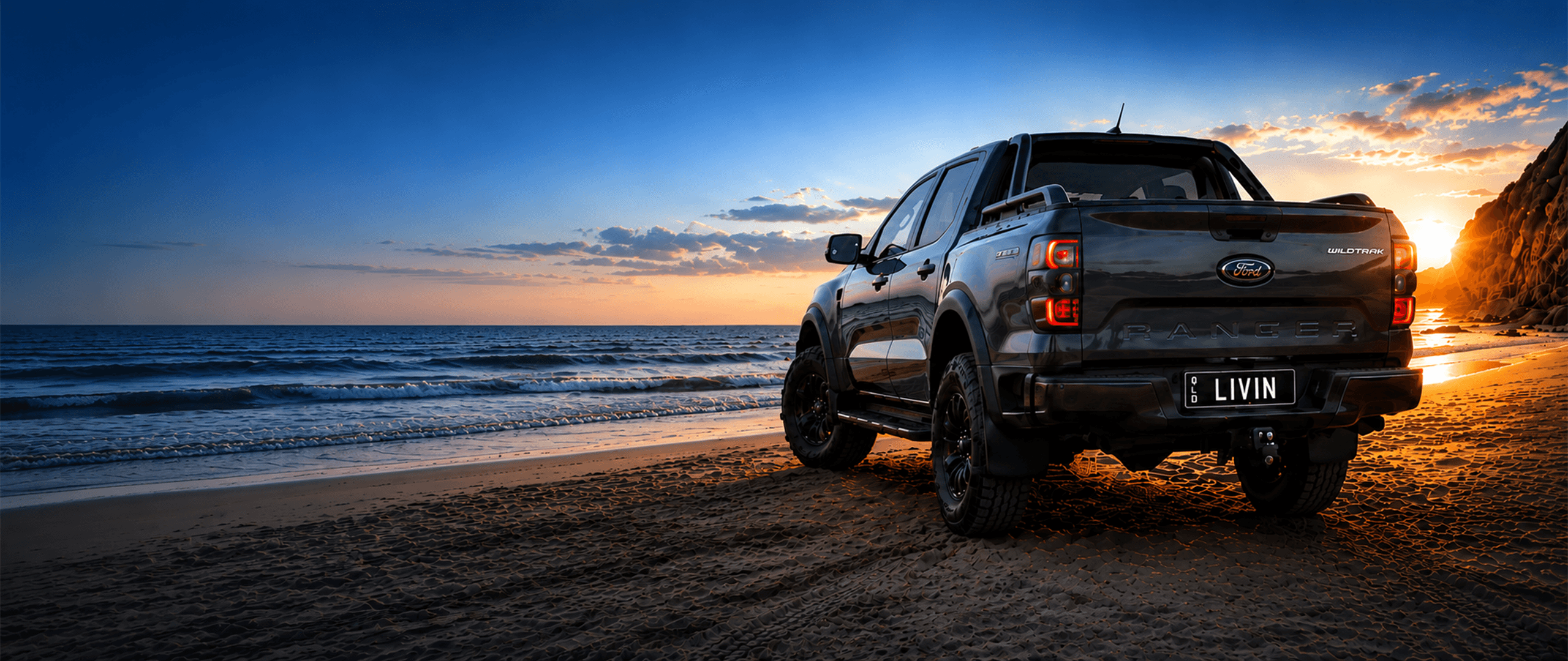 Ford Ranger Wildtrak on the beach at sunset with personalised LIVIN Queensland number plate